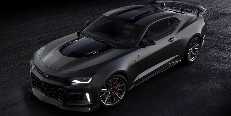 An all-new 2024 Black Chevy Camaro parked on a black asphalt lot. - Ted Britt Sterling, VA